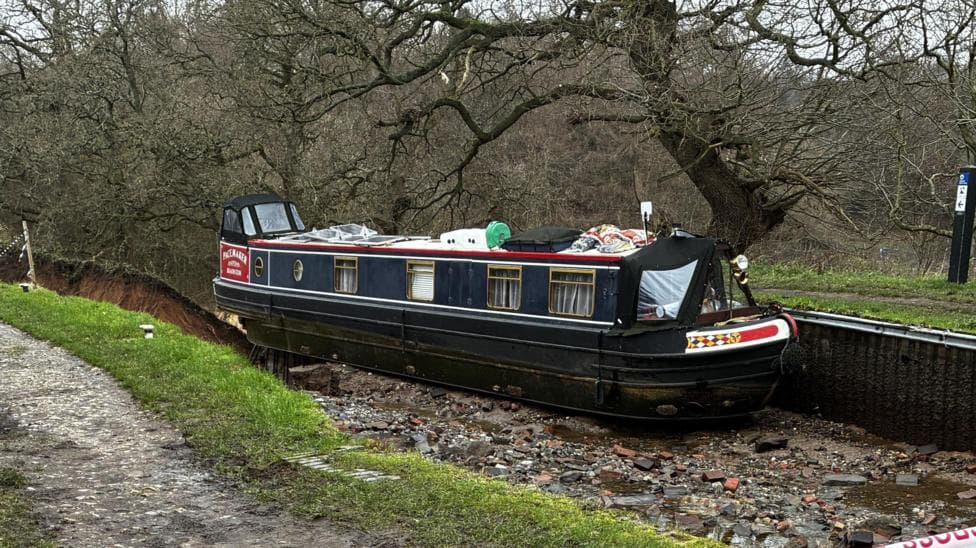 Boat stranded on edge of giant hole after canal collapse pulled to safety